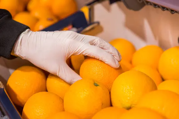 Man White Gloves Store Buys Food Man Holds Orange His — Stock Photo, Image