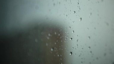 Pencerede yağmur damlaları. Bardağa su damlıyor. Yağmurlu hava
