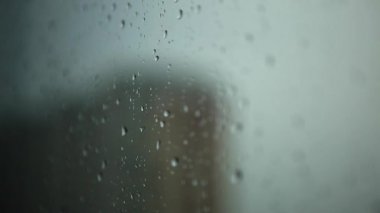 Pencerede yağmur damlaları. Bardağa su damlıyor. Yağmurlu hava