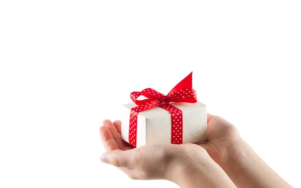Caja de regalo blanca con cinta roja en manos aisladas sobre fondo blanco — Foto de Stock