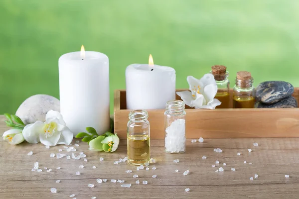 Aceites esenciales de aromaterapia en caja de madera, velas, flores y sal marina — Foto de Stock