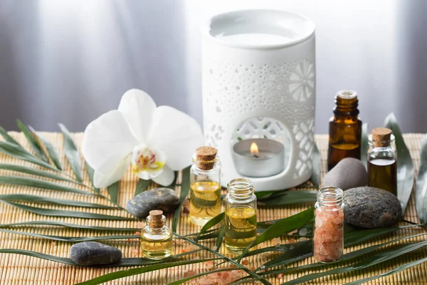 Aromatherapie ätherische Öle, Aromalampe, Blume und Steine Stockfoto