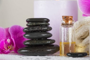Spa kavramı. Taşlar, esans, orkide çiçeği, mum