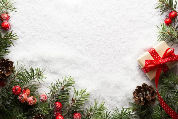 Рождественский фон с украшениями и подарочной коробкой на снегу — стоковое фото