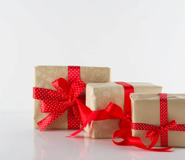Три коробки подарков с лентами на белом — стоковое фото
