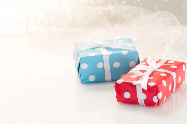 Geschenkboxen mit Bändern auf weißem Glitzerhintergrund — Stockfoto