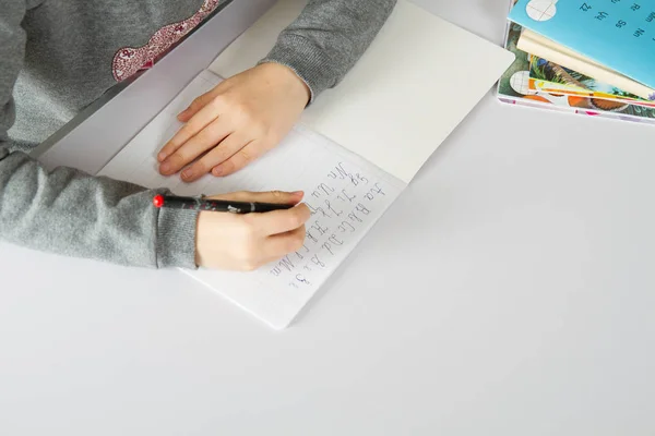 Chica haciendo tarea en la mesa blanca — Foto de Stock