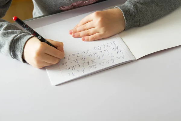 Девочка делает домашнее задание на белом столе — стоковое фото