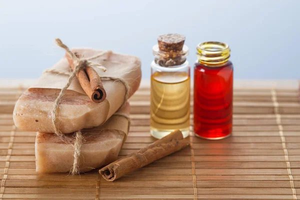 Handmade soaps, essential oils, cinnamon stick on wooden table — Stock Photo, Image