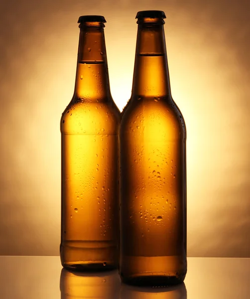 冷的两个啤酒瓶在玻璃桌上 — 图库照片
