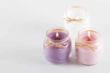 Beyaz mor, pembe ve beyaz mumlar yanan