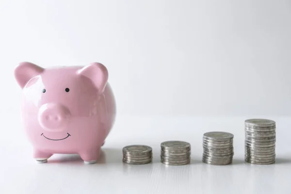 Images of stacking coins pile and pink smiling piggy bank to gro — Stock Photo, Image