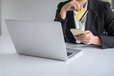 Akıllı telefon, kredi kartı ve yazma tutan genç kadın tüketici 