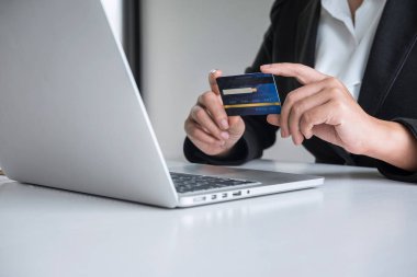 İş kadını tüketici Holding kredi kartı ve laptop yazarak