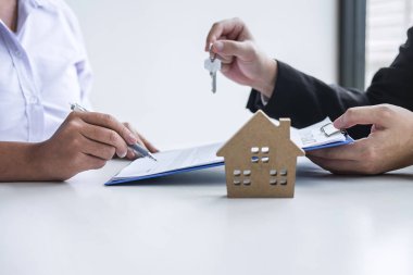Sözleşmenin imzalanmasından sonra istemciye evin anahtarları veren emlakçı