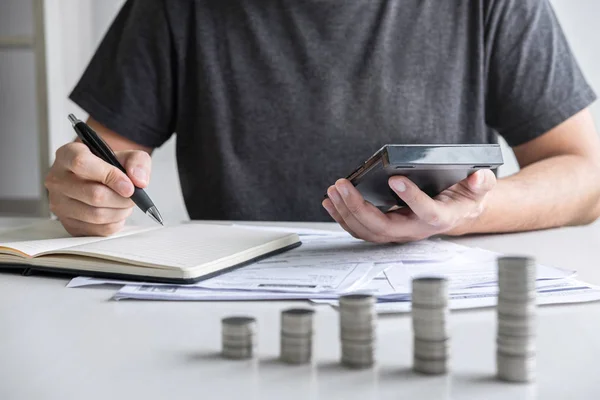 Imágenes de apilamiento de pila de monedas y el marido utilizando la calculadora a cal — Foto de Stock