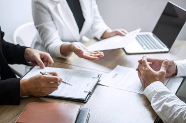 Aday profili, takım elbiseli işverenin iş görüşmesi, yönetici kaynakları istihdamı ve işe alım konsepti hakkında konuşurken özgeçmiş okuyan işveren ya da komite.
