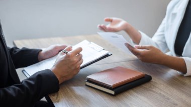 Aday profili, takım elbiseli işverenin iş görüşmesi, yönetici kaynakları istihdamı ve işe alım konsepti hakkında konuşurken özgeçmiş okuyan işveren ya da komite.