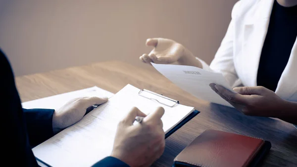 Employer or committee holding reading a resume with talking during about his profile of candidate, employer in suit is conducting a job interview, manager resource employment and recruitment concept.