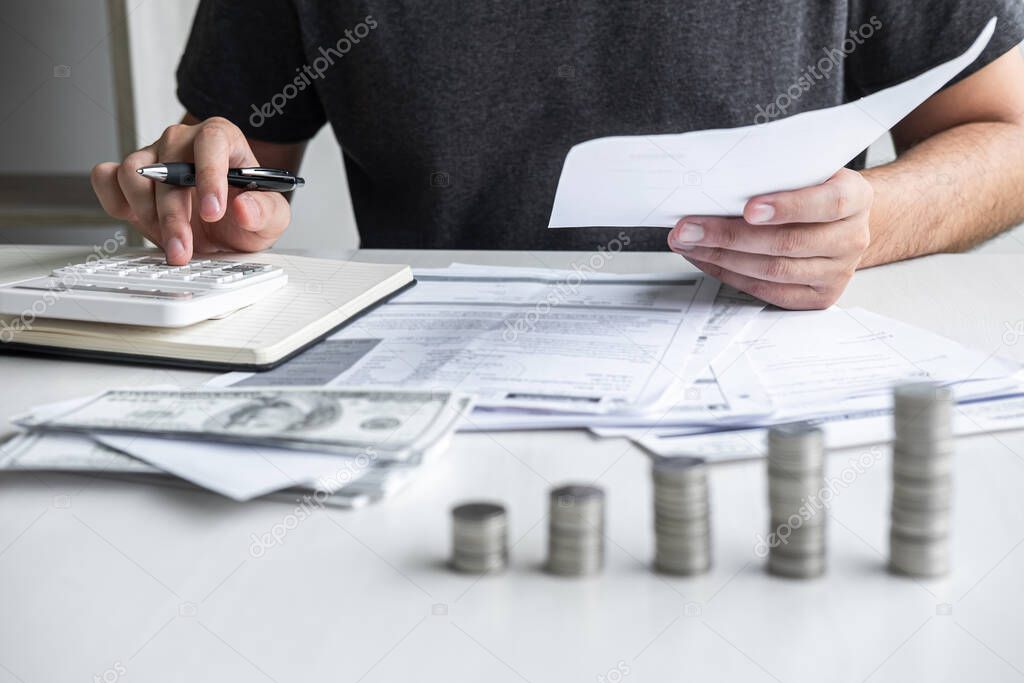 Images of stacking coin pile and Husband using calculator to calculating expenditure receipt bills of various activity cost and expenses in home office and written make report to plan of spent.