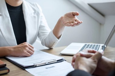 İşveren veya İşveren aday profili hakkında konuşurken bir özgeçmiş okuma tutan, takım elbiseli işveren bir iş görüşmesi, yönetici kaynak istihdam ve işe alma kavramı yürütmektedir.