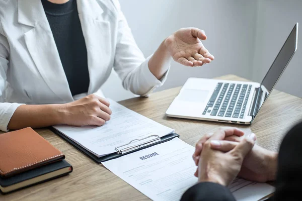 Employer or recruiter holding reading a resume with talking during about his profile of candidate, employer in suit is conducting a job interview, manager resource employment and recruitment concept.