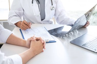 Profesör Doktor hasta ile konuşurken ve röntgen filmi çekerken aynı zamanda semptomları ya da teşhis, sağlık, sağlık ve yardım kavramlarını açıklarken.