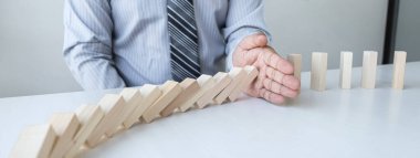 Risk ve strateji iş, el durdurma düşme çöküşü ahşap blok domino etkisi sürekli devrildi blok, önleme ve gelişme istikrarı.