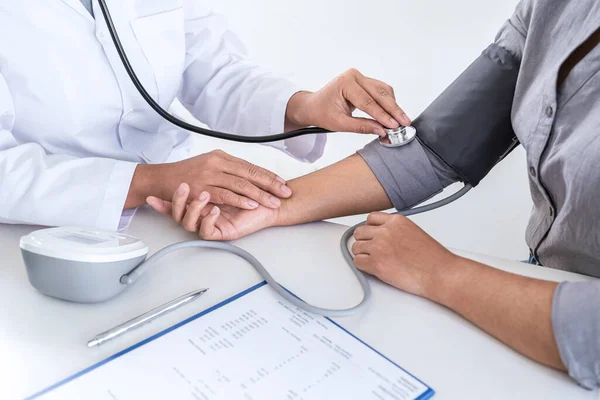 Doktor kan basıncını ölçerek hastayı muayene ederek, sonuçları sunarak ve tedavi yöntemi, sağlık ve tıbbi konsept önererek ölçüyor..
