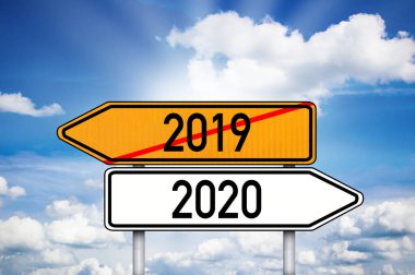 Alman yol işareti 2019 ve 2020 'yi gösteriyor. Arka planda mavi ve bulutlu gökyüzü var.