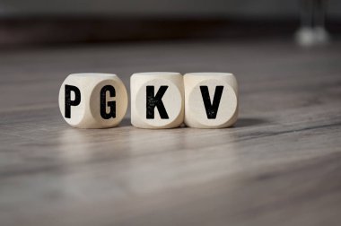 Ahşap arka planda Pkv ve GkV kısaltmalı küp ve zarlar