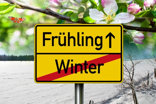 Road sign with the german words for spring and winter - frhling und winter