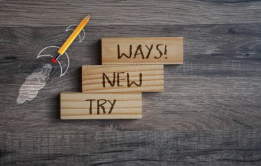 İş mesajlı kalem roketi. Yeni yollar dene! ahşap arkaplanda