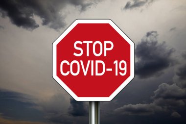 Karanlık bulutlu gökyüzü ile trafik işareti. Mesaj: Covid 19