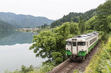 Fukushima, Japan - 18 Haziran: Yerel tren Tadami hat ve Tadami Nehri üzerinde 18 Haziran 2017: Fukushima, Japan. Bu tren Doğu Japonya demiryolu şirketin Tadami doğrultusunda.