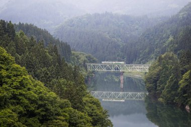 Fukushima, Japan - 19 Haziran: Yerel tren Tadami hat ve Tadami Nehri üzerinde 18 Haziran 2017: Fukushima, Japan. Bu tren Doğu Japonya demiryolu şirketin Tadami doğrultusunda.