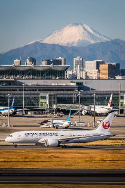 Dağ arka planda, Japonya havaalanında uçaklar.