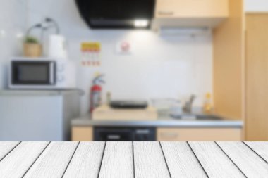 Küçük bir mutfakta beyaz ahşap bir masa.