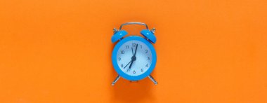 Blue alarm clock, onBlue alarm clock, on an orange background, minimalism an orange background, minimalism