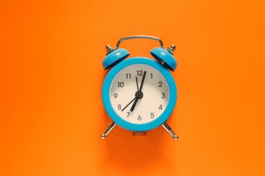 Back to school. Alarm clock on a bright orange background. Flat design.