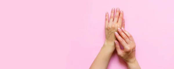女性の手は コピースペース 美しさ ケアコンセプトとピンクの背景に化粧品クリーム 化粧水を保湿 パターンフラットレイトップビューロングバナー — ストック写真