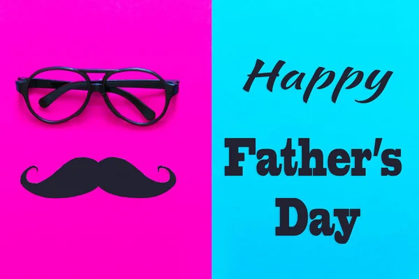 Father\'s Day. Bright holiday greeting card with the attributes of men mustache glasses on a bright blue-pink background. Flat top view