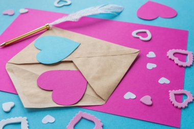 Sevgililer Günü. Tatil için hazırlık. Kâğıt kalpler, mavi arka planda kağıttan kesilmiş aşk sözleri. El yapımı, yaratıcılık