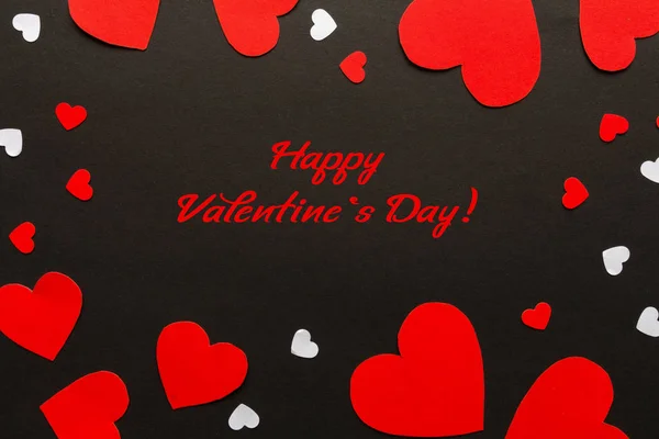 Valentines day. Paper red and white hearts on black background. Holiday background