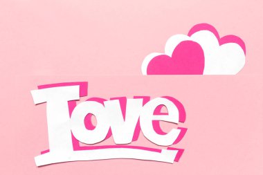 Sevgililer Günü için düzenleme kartı. Kağıt yapıştırma, origami, pembe arka planda el yapımı aşk sözcüğünün kalbi.