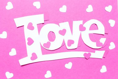 Sevgililer Günü için düzenleme kartı. Kağıt yapıştırma, origami, pembe arka planda el yapımı aşk sözcüğünün kalbi.