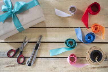 El yapımı hediye kutusu, yeşil bir fiyonk, ahşap arka planda üretimi için bir araç, üst görünüm, kopyalama alanı