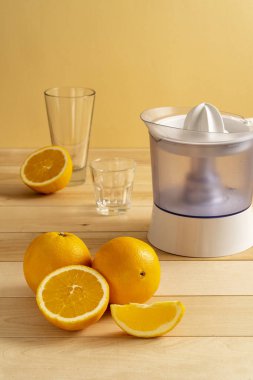 Cam kavanozdaki portakal suyu ve ahşap masadaki taze portakal dilimi.