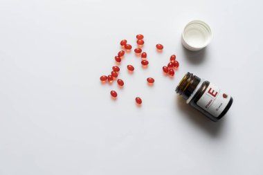 Açık kavanoz ve kırmızı kapsül hapları beyaz arka plan yatay çerçeve üzerinde, boşluk kopyala