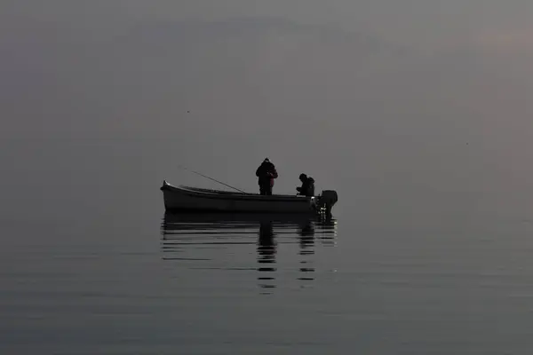 Човен з рибалками в зимовому тумані — стокове фото